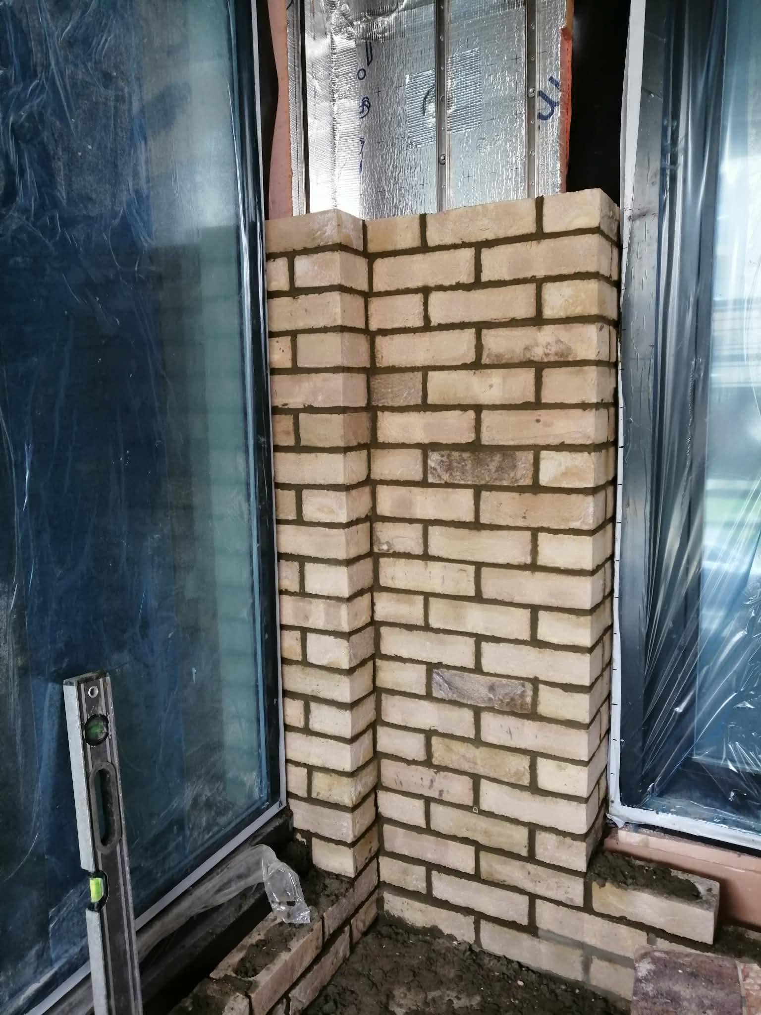 Kreminė klinkerio plytų kolona tarp langų